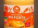 a jar of mustard with a spoon in it
