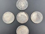 quatre pièces d'argent empilées les unes sur les autres sur une surface noire