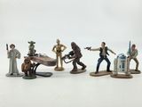 star wars action figures are lined up on a white surface