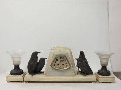 une horloge posée sur une table avec deux bougies