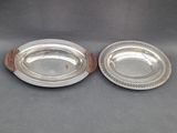 a pair of silverplated dishes on wooden bases