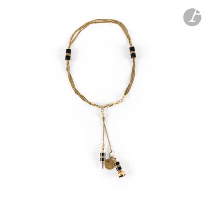 a gold and black necklace with two charms on a white background