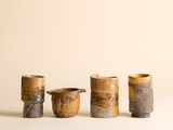 trois petites tasses posées les unes à côté des autres sur une surface blanche