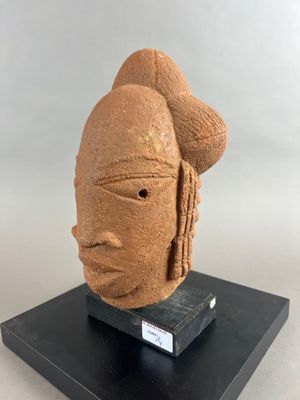 une sculpture représentant une tête de femme posée sur un socle noir