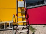 a red ladder leaning against a yellow wall next to a ladder