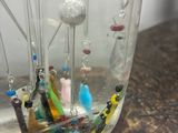 a glass jar with a bunch of pins in it