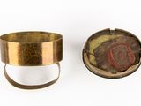 pair of antique brass cuff bracelets with a red and gold design