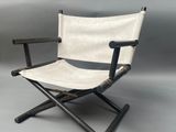 une image représentant une chaise pliante blanche et noire sur fond gris