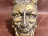 an image of a statue of a man with horns and a cross on his head