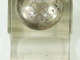 a silver button with a crown on it on a glass stand