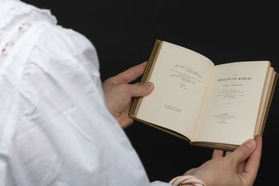 quelqu'un tient un livre dans ses mains et le regarde