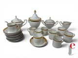 a white and gold tea set with cups and saucers