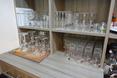 de nombreux verres et bouteilles sur les étagères de la pièce