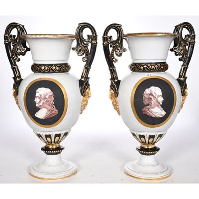 two white vases with black and gold trims with a portrait of a man and a woman on them