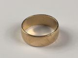 une image d'un gros plan d'une bague en or sur une surface blanche