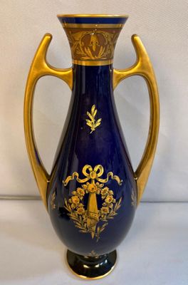 a blue and gold vase sitting on a white surface