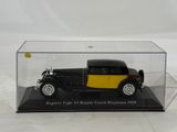a black and yellow model of a car in a display case