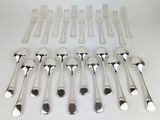 many forks and spoons laid out on the table