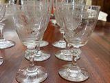 several empty wine glasses sitting on top of a wooden table