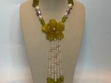 yellow and white beaded necklace with flowers and pearls on a mannequin