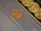 a gold coin sitting on a clear plastic case