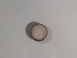 une pièce de monnaie posée sur une surface blanche