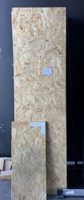 several pieces of plywood are stacked on a pallet in a warehouse