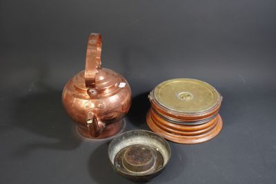 a copper teapot and a wooden coaster on a table
