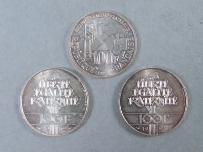 three silver coins sitting on top of a table next to each other