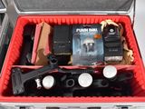 a red case filled with items that include a camera, flash light, and other items