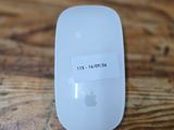 a white apple mouse sitting on top of a wooden table