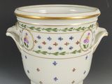 un grand bol blanc orné d'un liseré doré et de motifs floraux