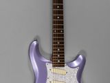 une guitare électrique violette posée sur une surface grise
