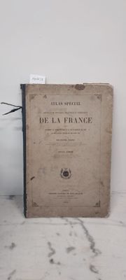 un livre posé par terre à côté d'un vase