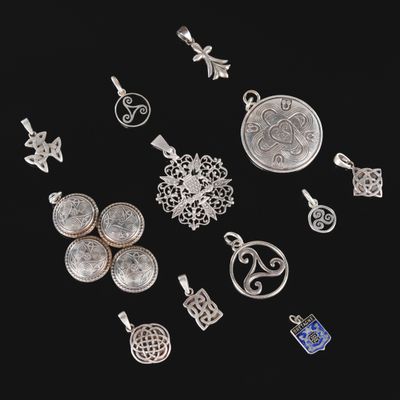 a group of silver jewelry on a black background