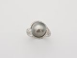 a black pearl and diamond ring on a white background