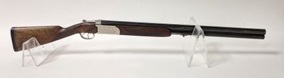 gros plan d'un fusil posé sur un support sur une surface blanche