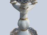 a white vase with blue flowers on it on a plate
