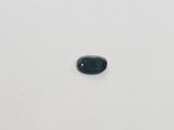 a blue sapphire stone on a white surface