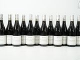 six bouteilles de vin sont alignées sur une table