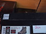 someone is holding a box with a pair of shoes on top of it