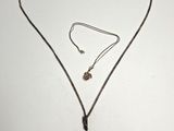 un gros plan d'un collier et d'une boucle d'oreille posés sur une surface blanche