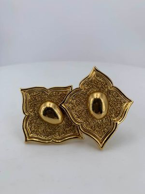 a pair of gold tone earrings with a flower design