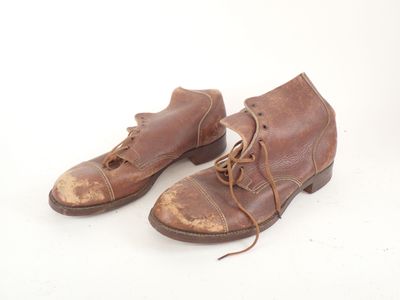 pair of brown leather shoes with laces on them on a white surface