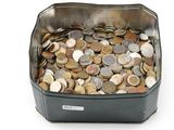 un récipient métallique rempli de pièces de monnaie posé sur une surface blanche
