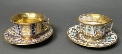 two cups and saucers are sitting on a table