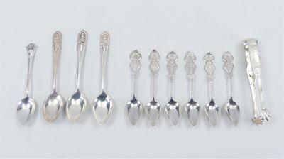 six silver spoons and two silver spoons on a white surface
