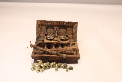 une petite boîte en bois contenant un tas de vis