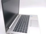 a silver laptop computer sitting on a white surface