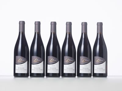six bottles of wine are lined up on a table